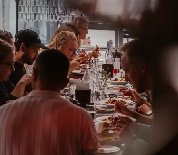 Nöjda gäster som umgås runt ett bord på en livlig bar och slipper köa till